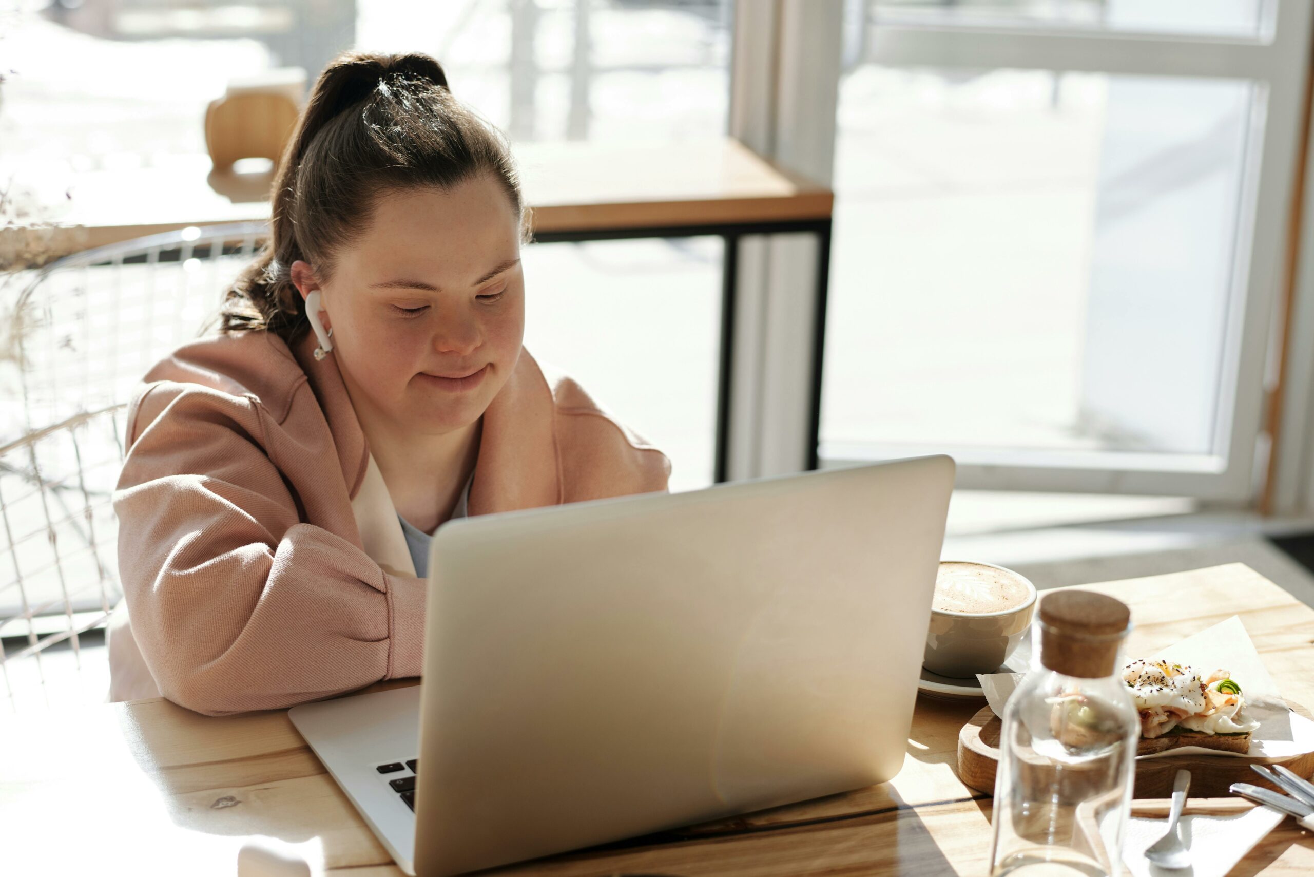 Junges Mädchen benutzt einen Laptop beim Frühstück